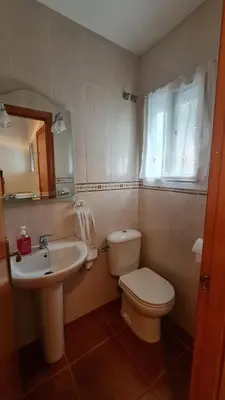 a bathroom with a white toilet and a sink at Vaca House in El Puerto de Santa María