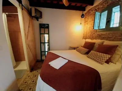 a bedroom with a large bed and a brick wall at Kala Almendrillo Apartment Boutique in Jerez de la Frontera