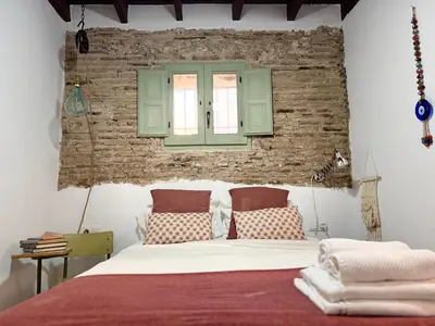 a bedroom with a bed and a brick wall at Kala Almendrillo Apartment Boutique in Jerez de la Frontera