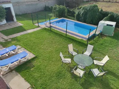 a yard with a table and chairs and a swimming pool at Casa Rural con Piscina Verdugo in El Puerto de Santa María