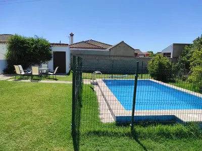 a fence around a swimming pool in a yard at Casa Rural con Piscina Verdugo in El Puerto de Santa María