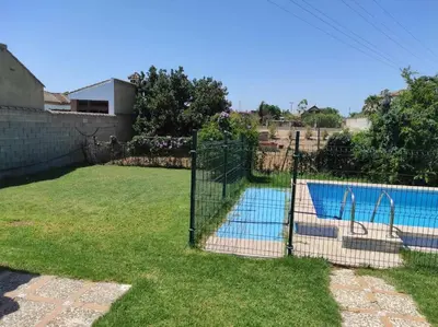 a gate in a yard with a swimming pool at Casa Rural con Piscina Verdugo in El Puerto de Santa María