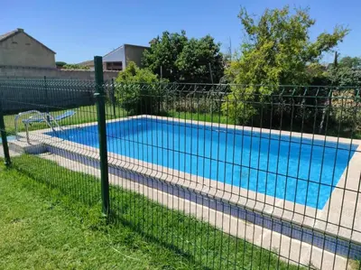 a fence around a swimming pool in a yard at Casa Rural con Piscina Verdugo in El Puerto de Santa María