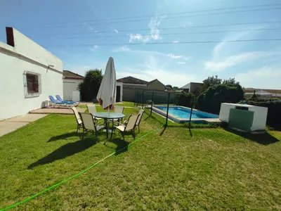 a patio with a table and a umbrella and a pool at Casa Rural con Piscina Verdugo in El Puerto de Santa María