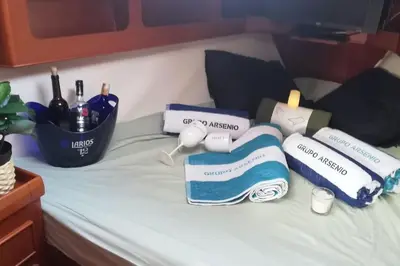 a bed with towels and wine bottles on it at Boat-Apartamento flotante Cádiz.. La Juanita Arroyo in Cádiz