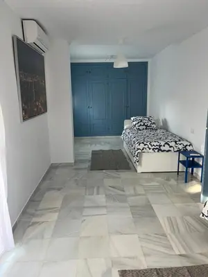 a bedroom with a bed and a tiled floor at Fuentebravia House in El Puerto de Santa María