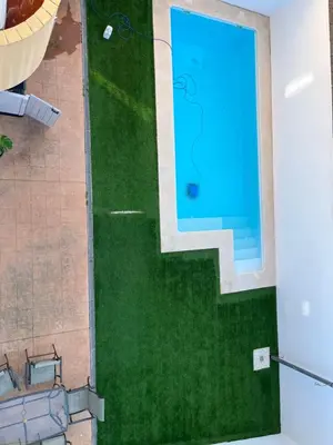 an overhead view of a swimming pool with green grass at Fuentebravia House in El Puerto de Santa María