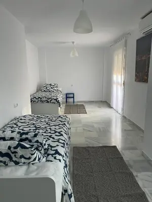 a bedroom with two beds and a tile floor at Fuentebravia House in El Puerto de Santa María