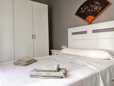 a bedroom with a white bed with towels on it at Ático San Agustín - Panoramic View in Jerez de la Frontera