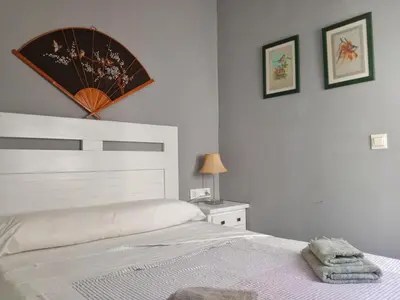 a bedroom with a bed and a mirror on the wall at Ático San Agustín - Panoramic View in Jerez de la Frontera
