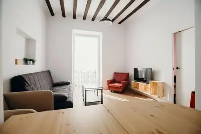 a living room with a table and a couch and a tv at Habana Vieja Cádiz in Cádiz