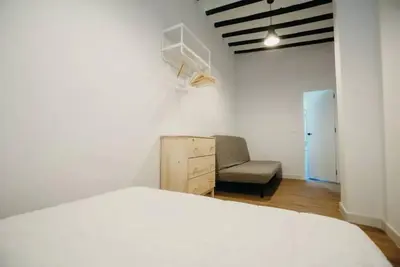a bedroom with a bed and a chair in it at Habana Vieja Cádiz in Cádiz