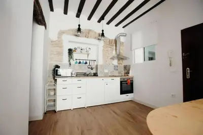 a kitchen with white cabinets and a wooden floor at Habana Vieja Cádiz in Cádiz