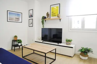a living room with a tv and a coffee table at El Apartamento de Nueva in Cádiz