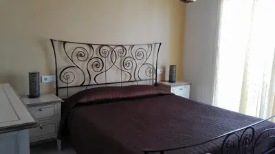 a bedroom with a large bed with a metal headboard at Atico con terraza en centro-playa in Sanlúcar de Barrameda