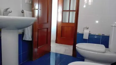 a bathroom with a white toilet and a sink at Atico con terraza en centro-playa in Sanlúcar de Barrameda