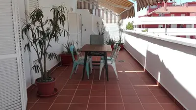 a patio with a table and chairs on a balcony at Atico con terraza en centro-playa in Sanlúcar de Barrameda