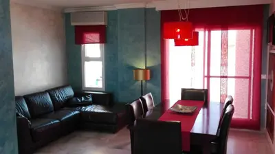 a living room with a couch and a dining room table at Atico con terraza en centro-playa in Sanlúcar de Barrameda