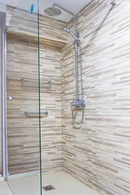 a shower in a bathroom with a wooden wall at Casa de campo, llena de encanto junto al mar in Cádiz