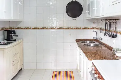 a kitchen with white cabinets and a sink at Casa de campo, llena de encanto junto al mar in Cádiz