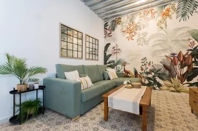 a living room with a green couch and a table at Apartamento El Mural in Jerez de la Frontera