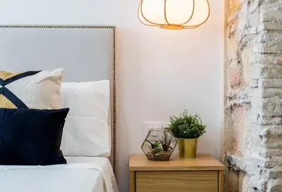 a bedroom with a bed and a table with a plant at Apartamento El Mural in Jerez de la Frontera