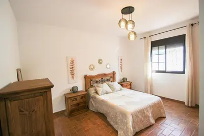 a bedroom with a bed and a dresser and a window at Vivienda Rural El Chirimbolo in Conil de la Frontera