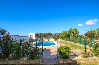 a garden with a swimming pool and flowers at Vivienda Rural El Chirimbolo in Conil de la Frontera
