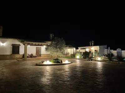 a courtyard at night with a fountain in the middle at Vivienda Rural El Chirimbolo in Conil de la Frontera