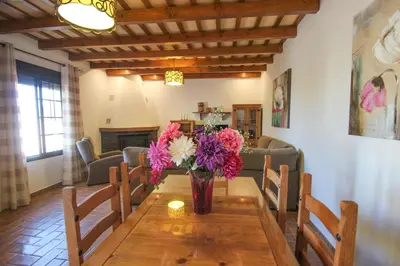 a vase of flowers on a wooden table in a living room at Vivienda Rural El Chirimbolo in Conil de la Frontera