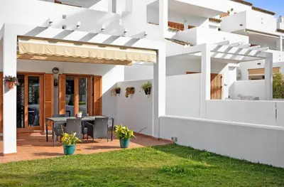 a white house with a patio and grass at Carrajolilla Sancti petri in Chiclana de la Frontera