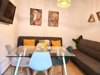 a dining room with a table and a couch at Acogedor apartamento in Rota