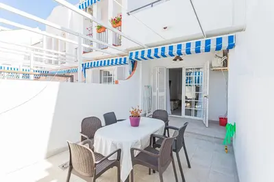 a dining room with a white table and chairs at Dúplex 8, en primera línea de playa in Sanlúcar de Barrameda