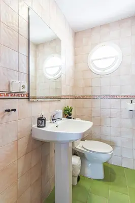 a bathroom with a sink and a toilet at Dúplex 8, en primera línea de playa in Sanlúcar de Barrameda
