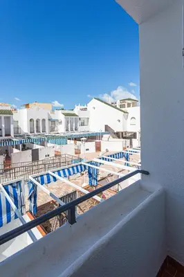 a balcony with a view of a beach and buildings at Dúplex 8, en primera línea de playa in Sanlúcar de Barrameda
