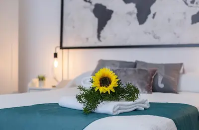 a bouquet of a sunflower on a bed at Rianal Céntrico Moderno in Jerez de la Frontera