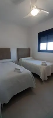 a bedroom with two beds and a window at APARTAMENTO TURISTICO EN LEBRIJA in Lebrija