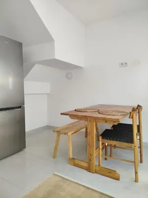 a wooden table in a kitchen next to a refrigerator at APARTAMENTO TURISTICO EN LEBRIJA in Lebrija