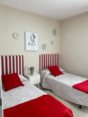 two beds in a room with red and white at OLEAJE in Sanlúcar de Barrameda