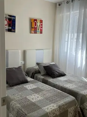 a bedroom with two beds and a window at OLEAJE in Sanlúcar de Barrameda