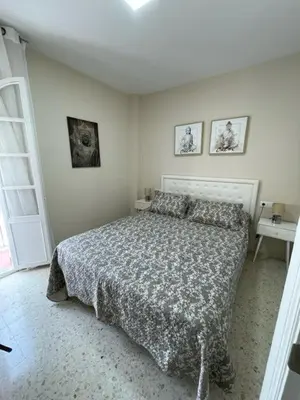 a bedroom with a bed in a white room at OLEAJE in Sanlúcar de Barrameda