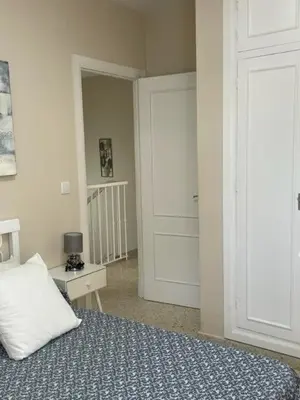 a bedroom with a bed and a door to a hallway at OLEAJE in Sanlúcar de Barrameda