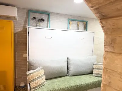 a large white garage door with a green couch at Estudio Interior Kala - Only Adults - Private Room in Jerez de la Frontera