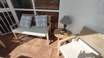 a room with a chair and a table and a lamp at Apto. en la playa del parque natural los Turuños in El Puerto de Santa María