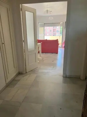 an empty hallway with a door and a red couch at Piso de 3 dormitorios con garaje in Jerez de la Frontera