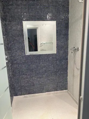 a black and white tiled shower with a mirror at Piso de 3 dormitorios con garaje in Jerez de la Frontera