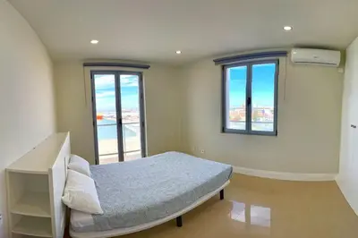 a bedroom with a bed and two windows at Apartamento Fenix - Recién renovado y vistas al mar in Cádiz