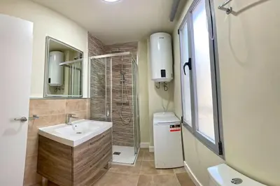a bathroom with a sink and a shower and a mirror at Apartamento Fenix - Recién renovado y vistas al mar in Cádiz
