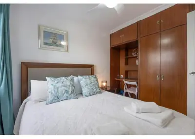 a bedroom with a large white bed with wooden cabinets at La Rosa de Oro in Jerez de la Frontera