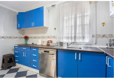 a blue kitchen with a sink and a dishwasher at La Rosa de Oro in Jerez de la Frontera
